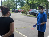 Dino discusses with a woman at an outreach - Jun 2020